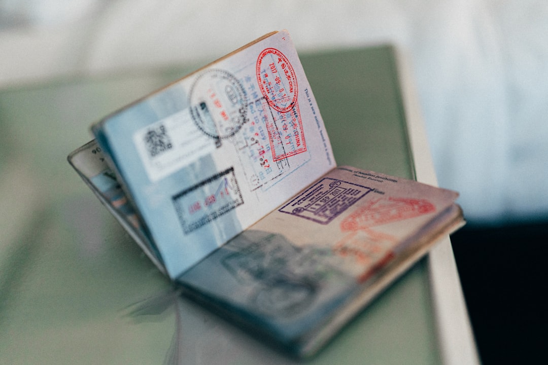 Розгорнутий закордонний паспорт зі штампами прикордонного контролю на столі